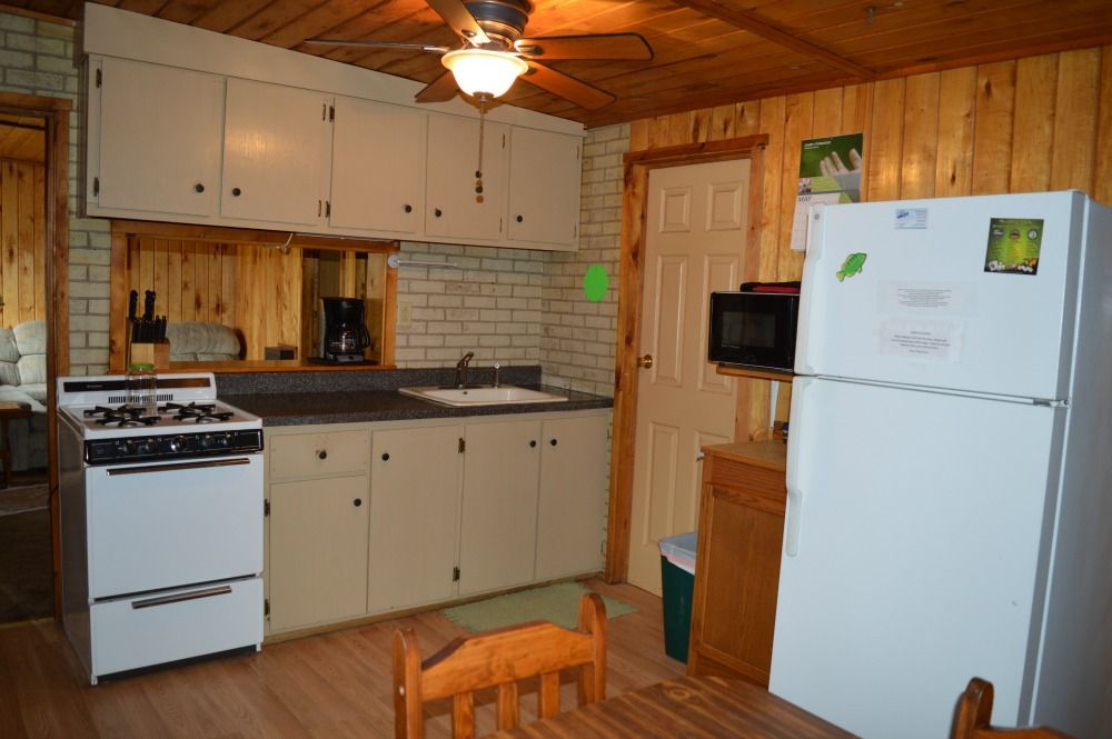 a kitchen with a stove, refrigerator, sink and microwave