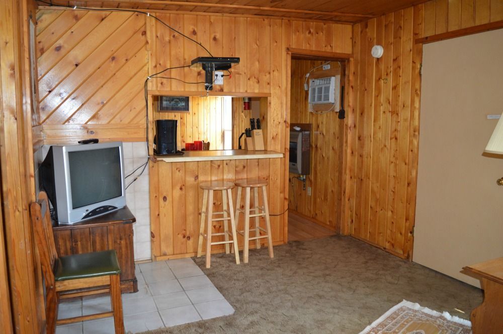 a living room with wood paneling and a flat screen tv