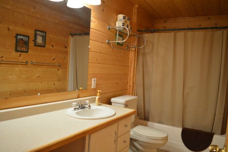 a bathroom with a sink, toilet, tub and mirror