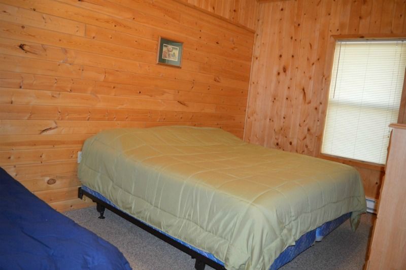 a bedroom with a bed and a window in a log cabin
