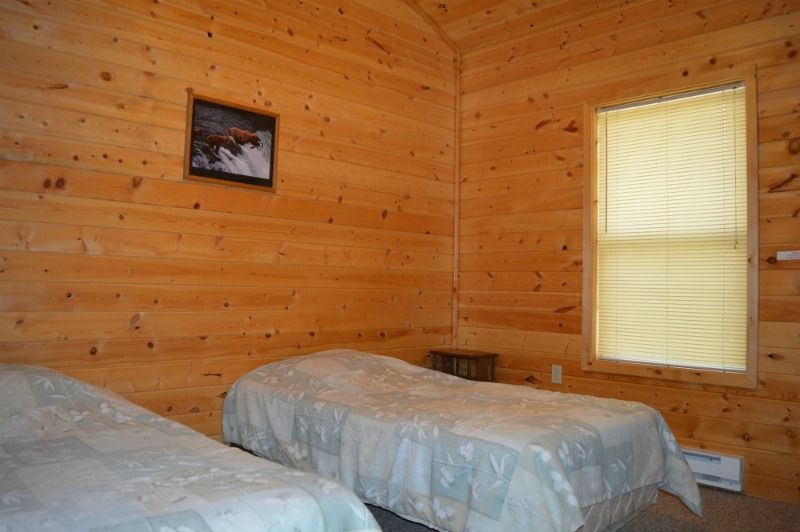 a bedroom in a log cabin with two twin beds and a window