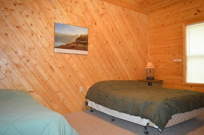 a bedroom with two beds and a picture on the wall