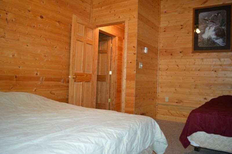 a bedroom in a log cabin with a bed and two beds