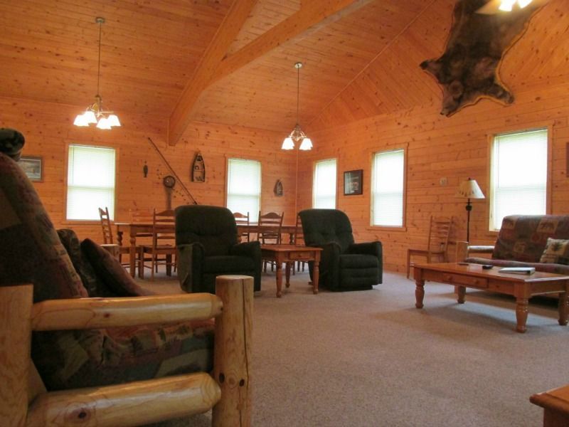a living room in a log cabin with a bear hanging from the ceiling