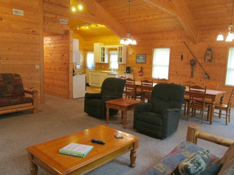 a living room in a log cabin with a table and chairs