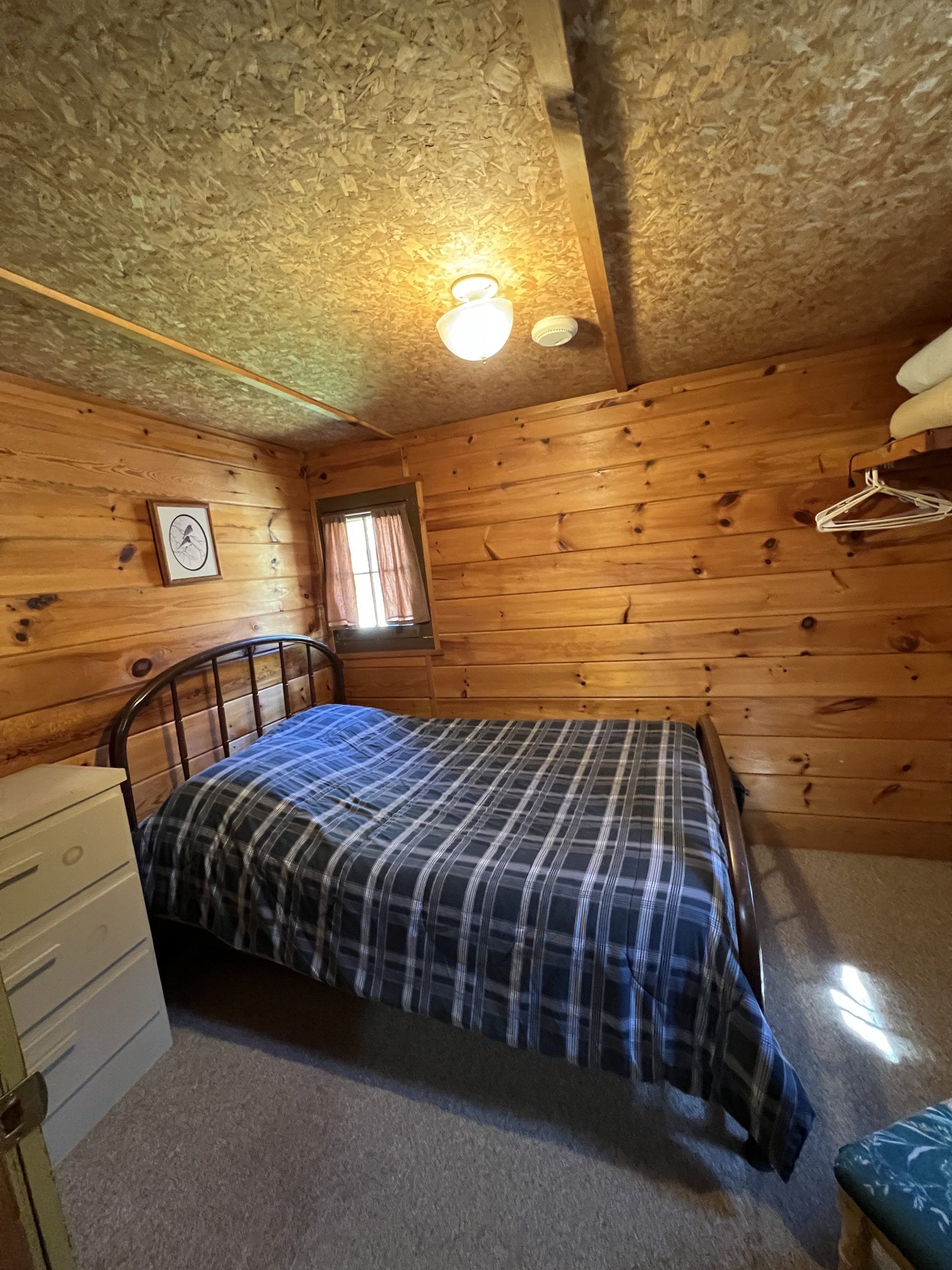 a bedroom in a log cabin with a bed and dresser