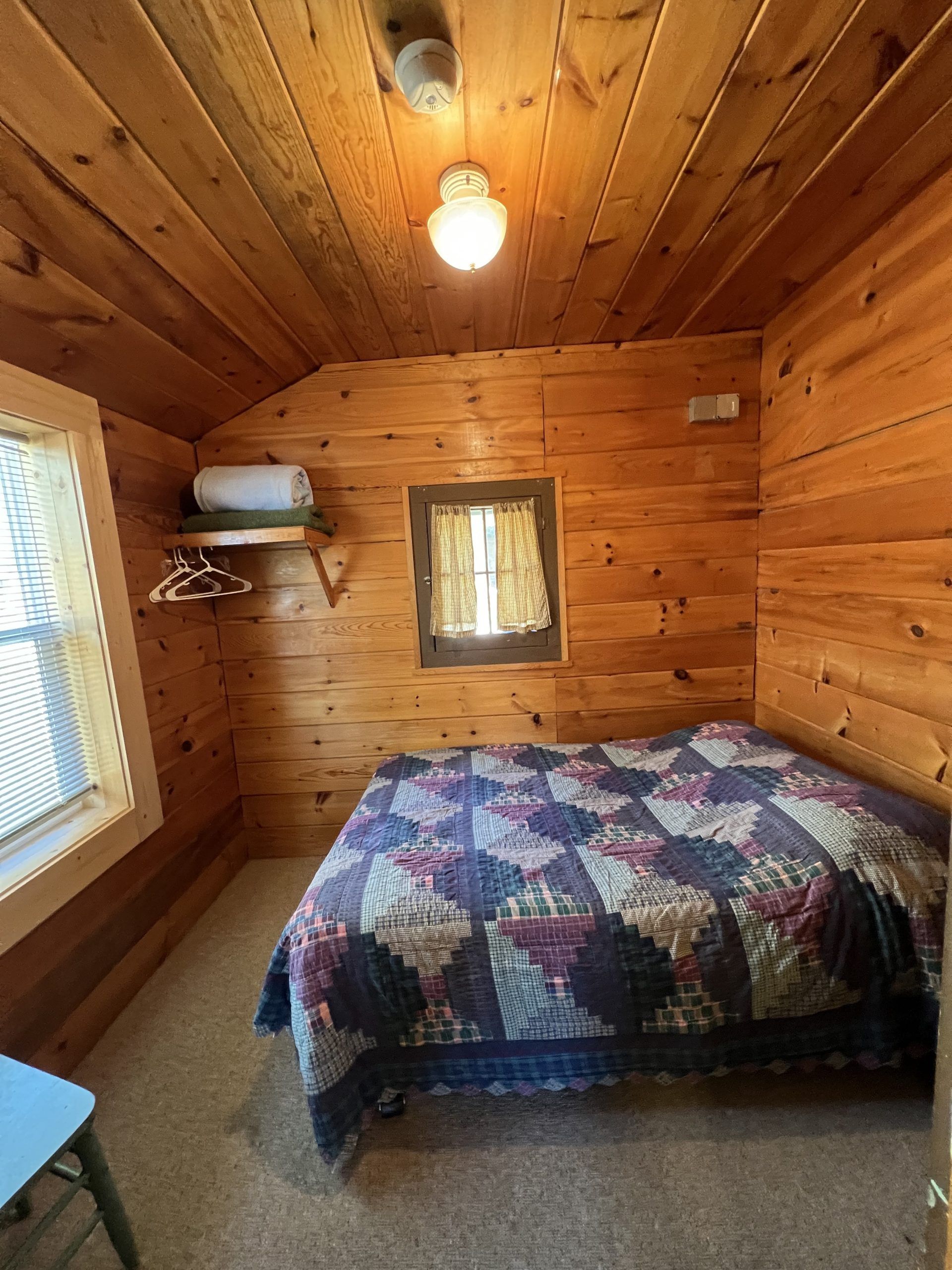 a bedroom in a log cabin with a bed and a window