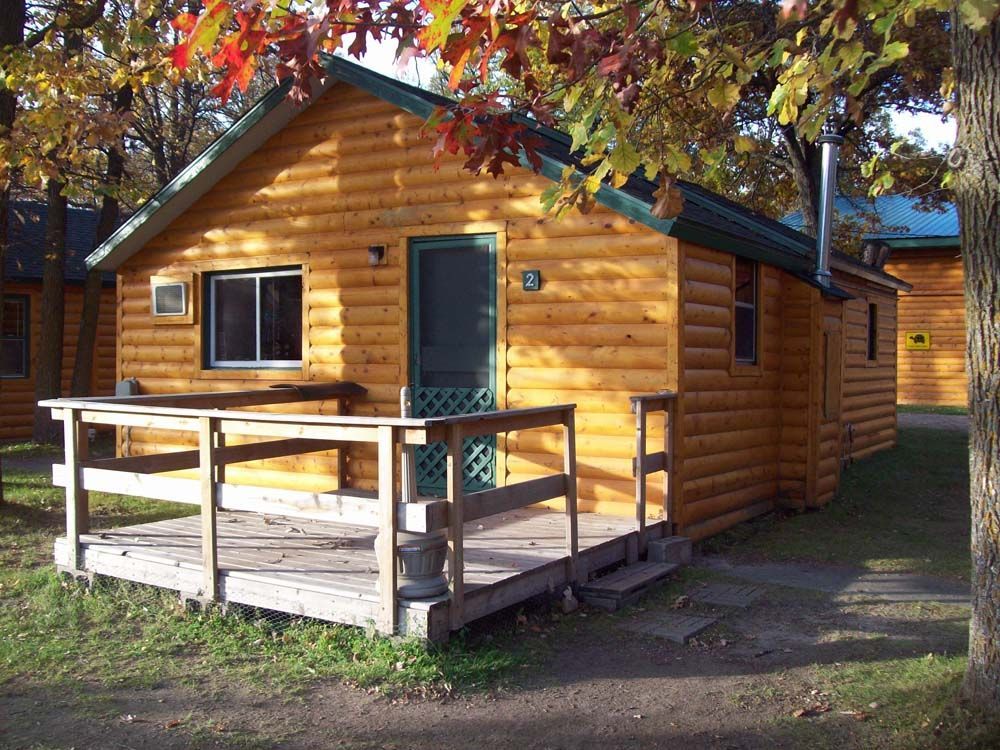 a small log cabin with a porch in front of it