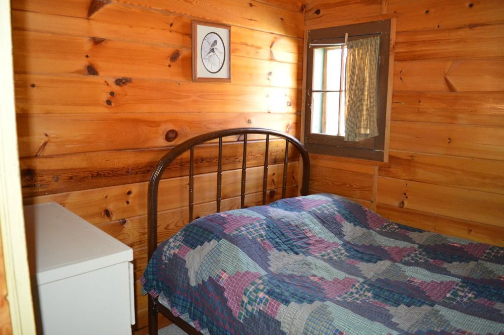 a bedroom in a log cabin with a bed and a clock on the wall