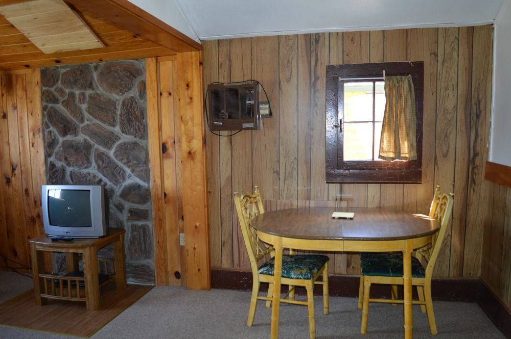 a living room with a table and chairs and a television