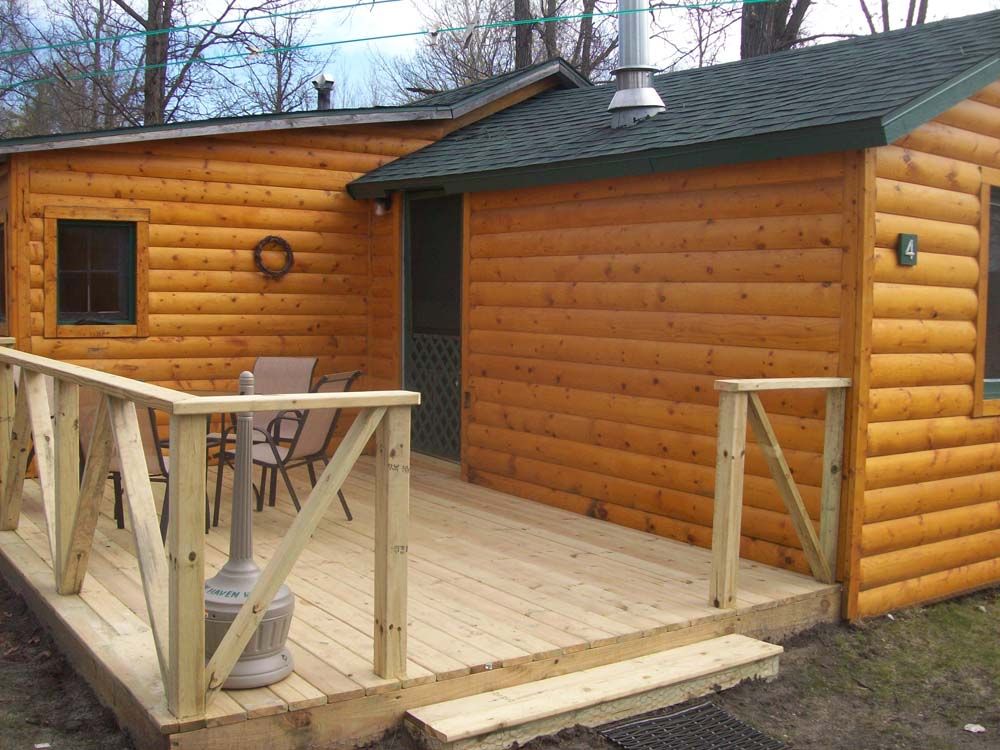 a log cabin with a wooden deck and stairs