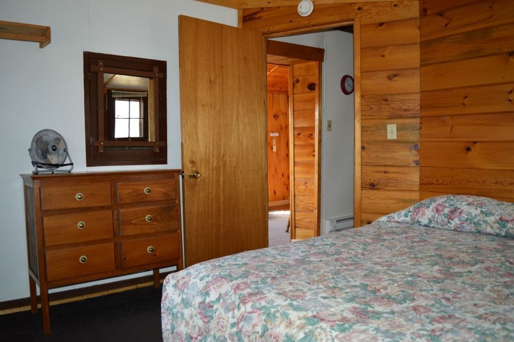 a bedroom with a bed a dresser and a mirror