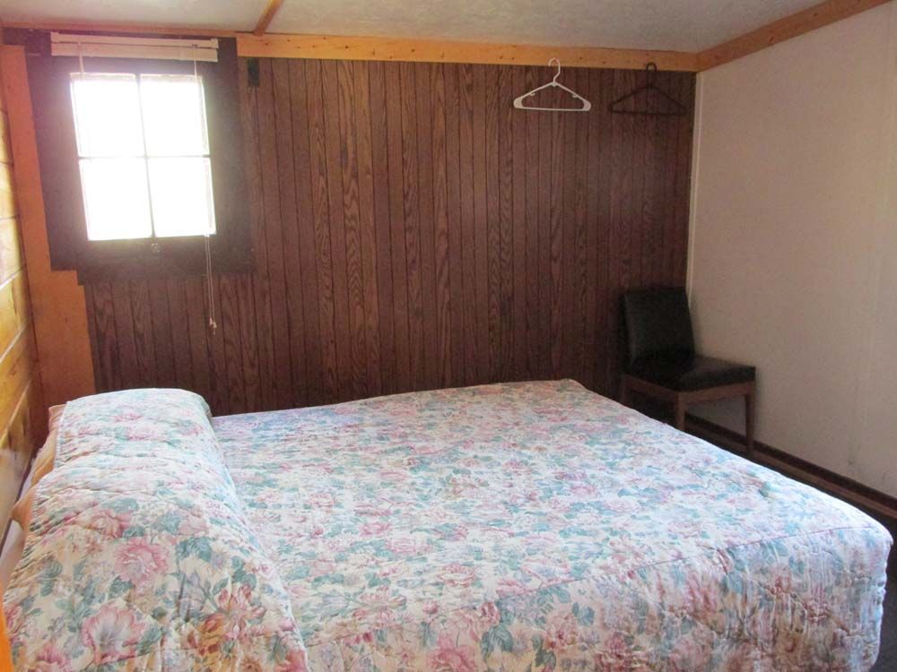 a bedroom with a bed, chair and window