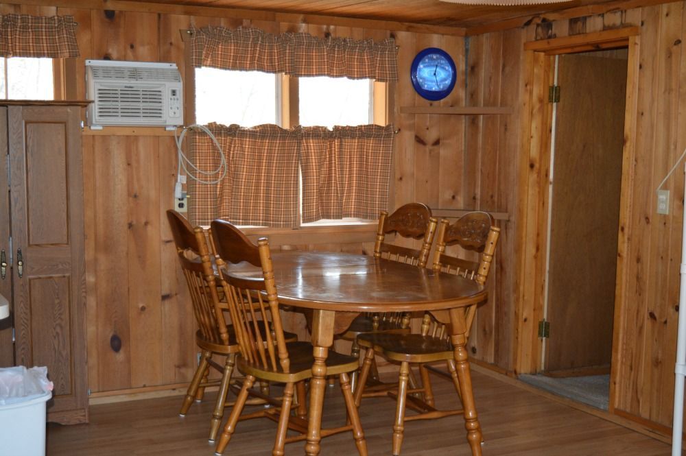 a wooden dining room with a table and chairs and a blue clock on the wall