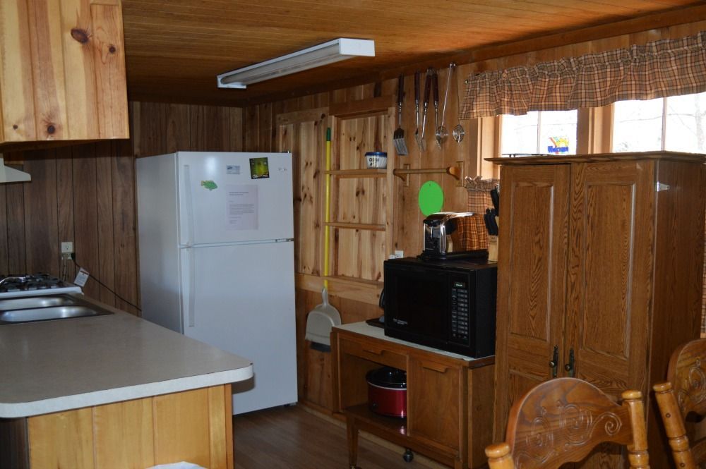 a kitchen with a refrigerator, microwave, stove and sink