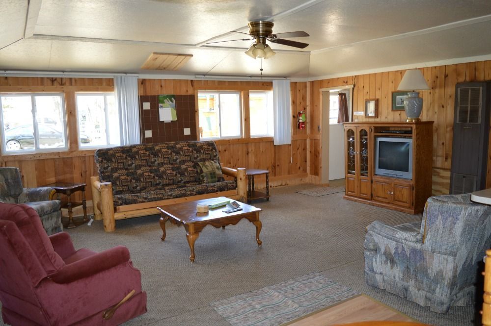 a living room with a couch, chairs, coffee table and television