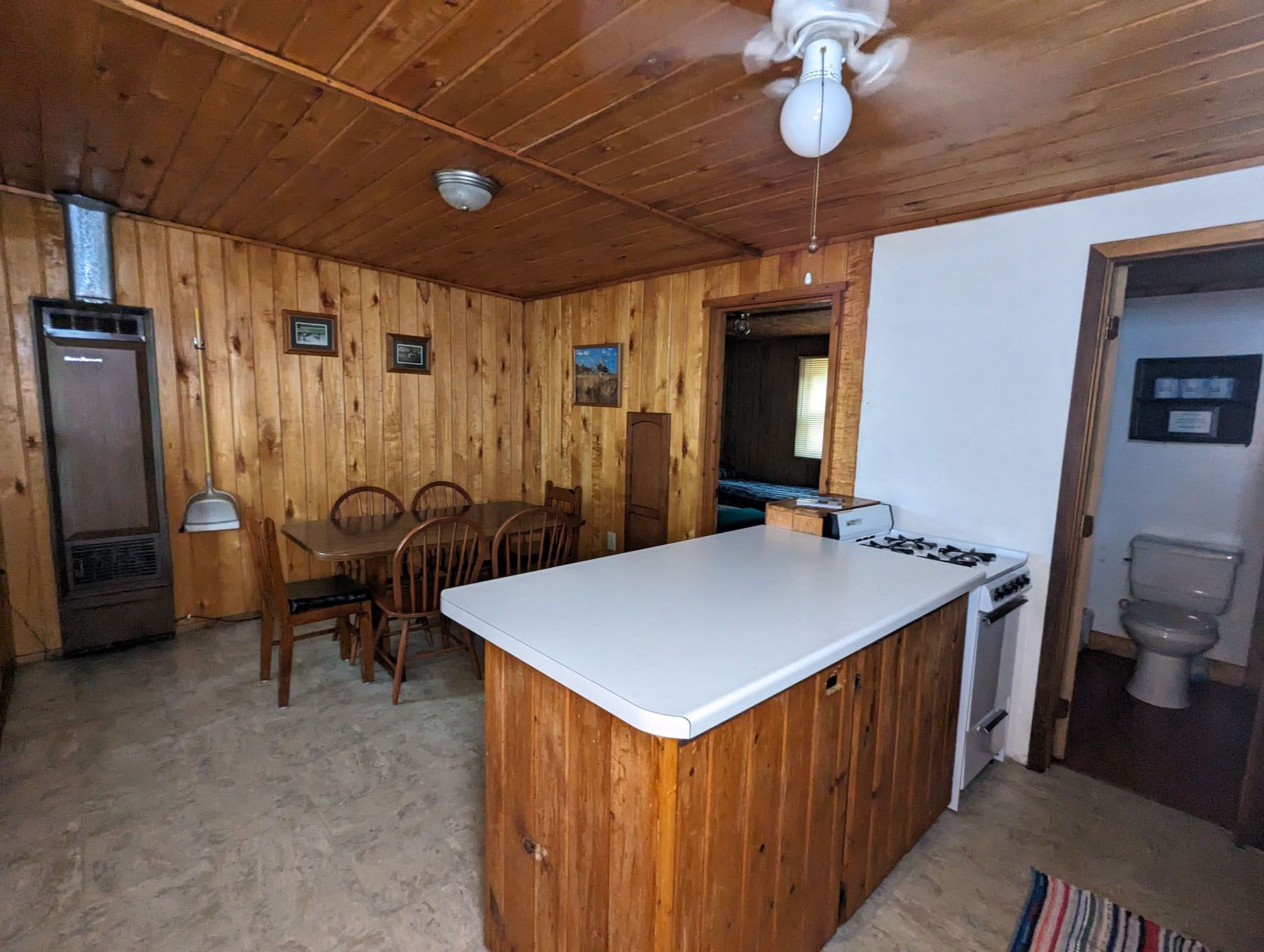 a kitchen with a large island, stove, table and chairs
