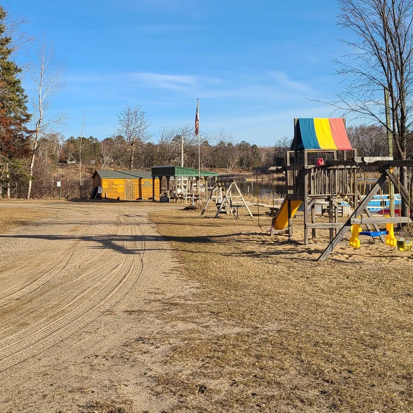 a dirt road with a playground in the background