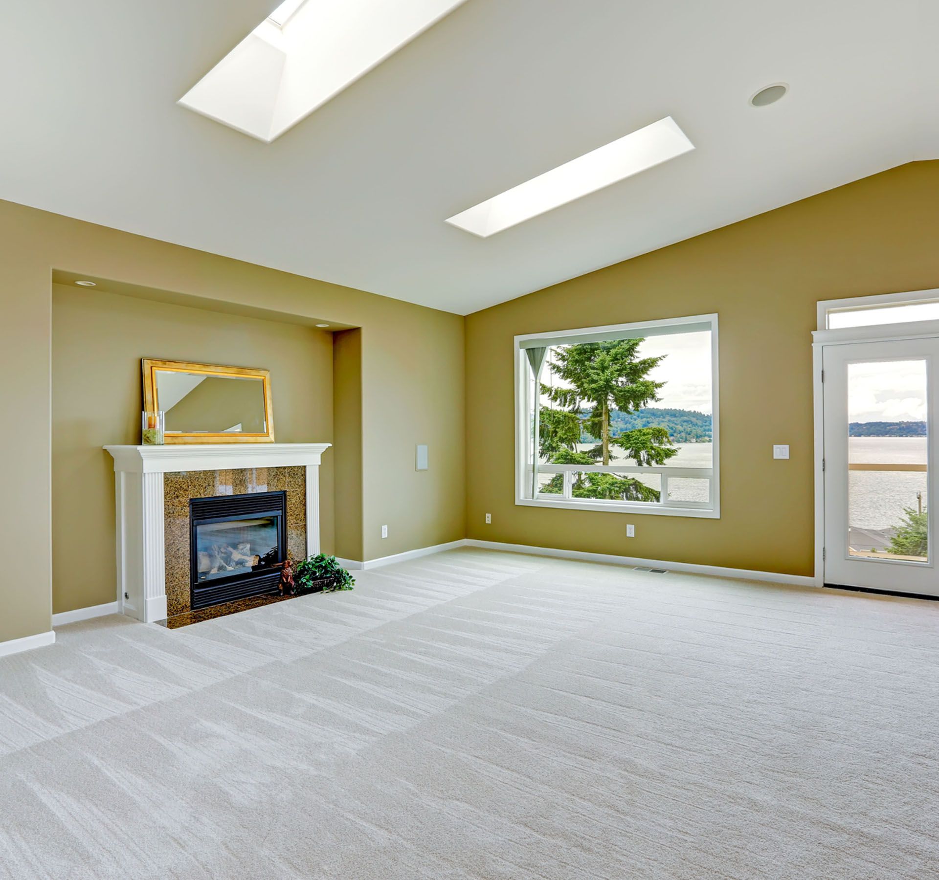 An empty living room with a fireplace and a large window