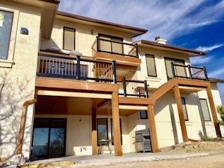 A large house with a large deck and stairs leading up to it.