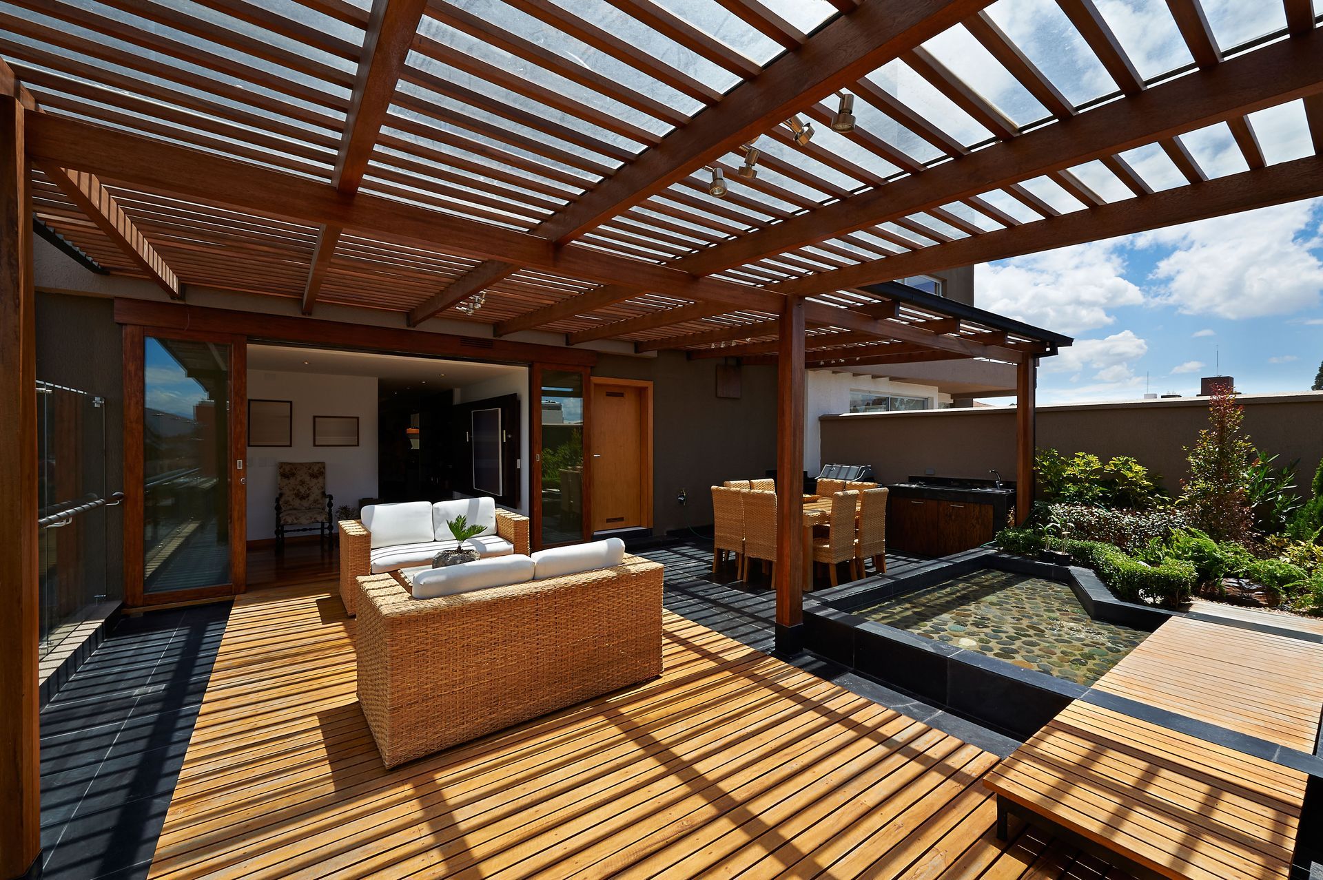 A wooden deck with a pergola and a couch.