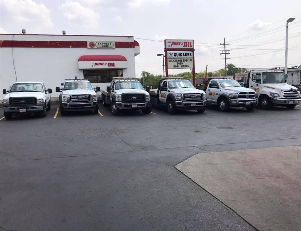 Several pickup trucks parked in front of a gas station on a cloudy day.