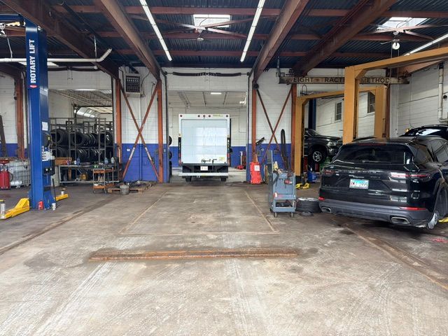 Auto repair garage with car lifts, tools, and a black SUV parked inside