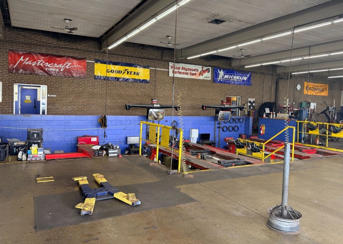 Auto repair shop interior with lifts, tools, and cars on a concrete floor
