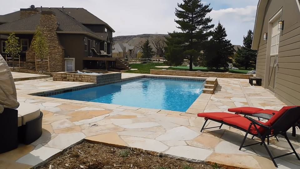 A large swimming pool is in the backyard of a house