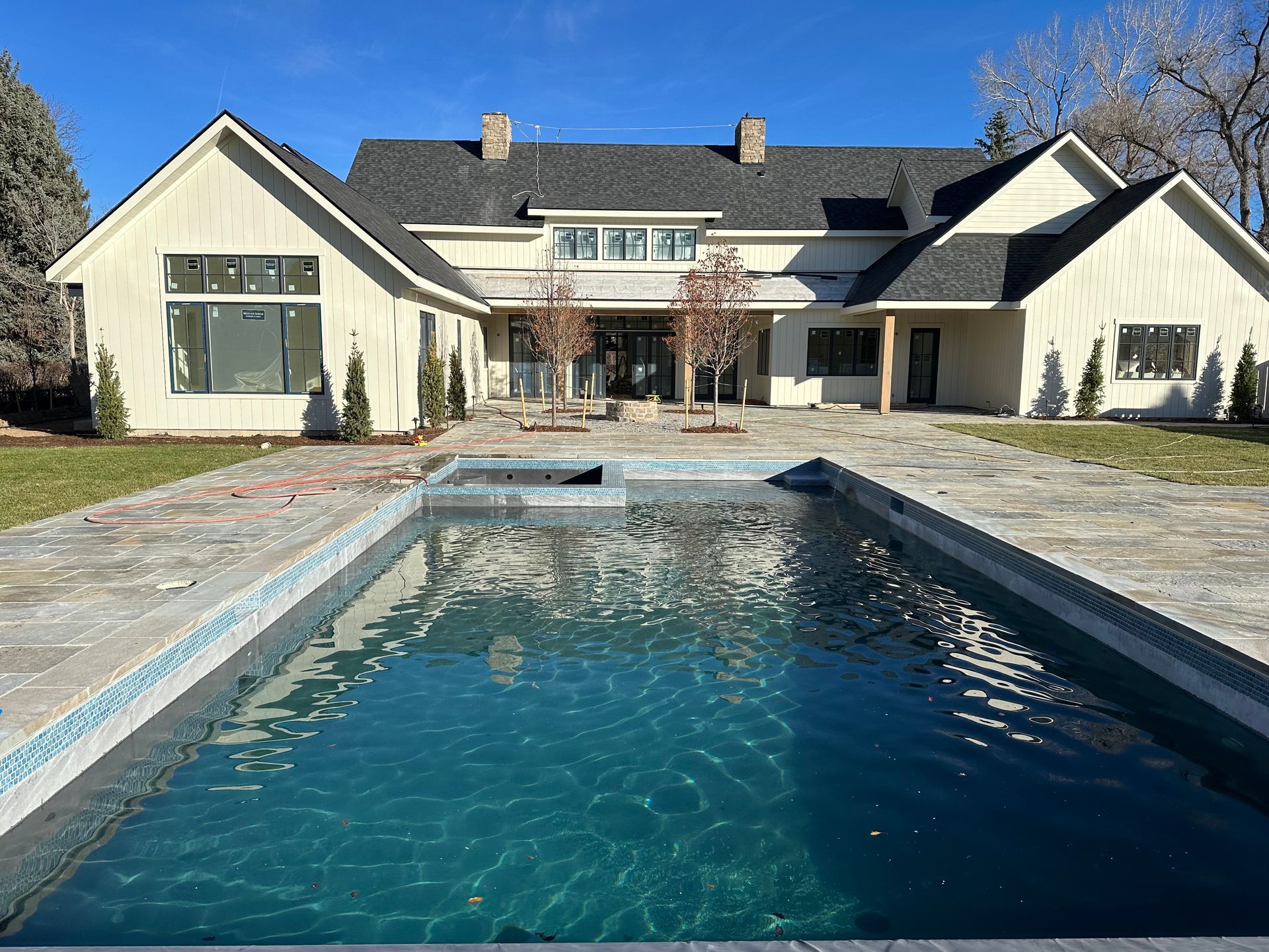 A large house with a large swimming pool in front of it.