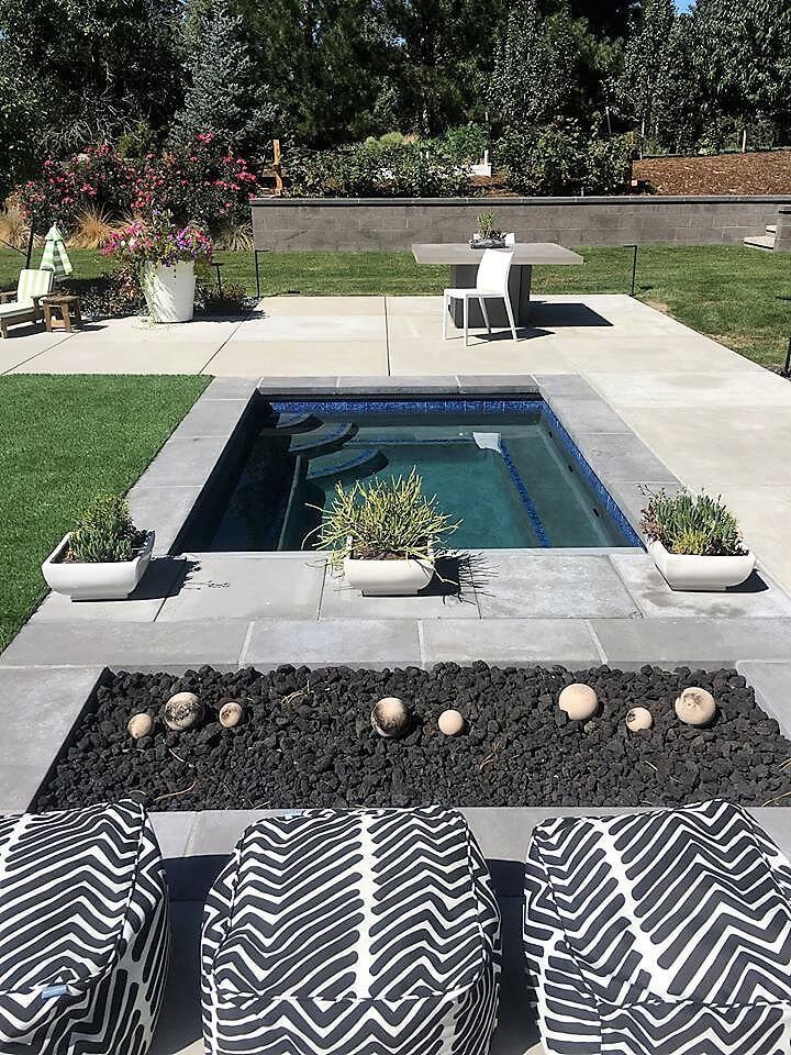 There is a swimming pool in the middle of the backyard.