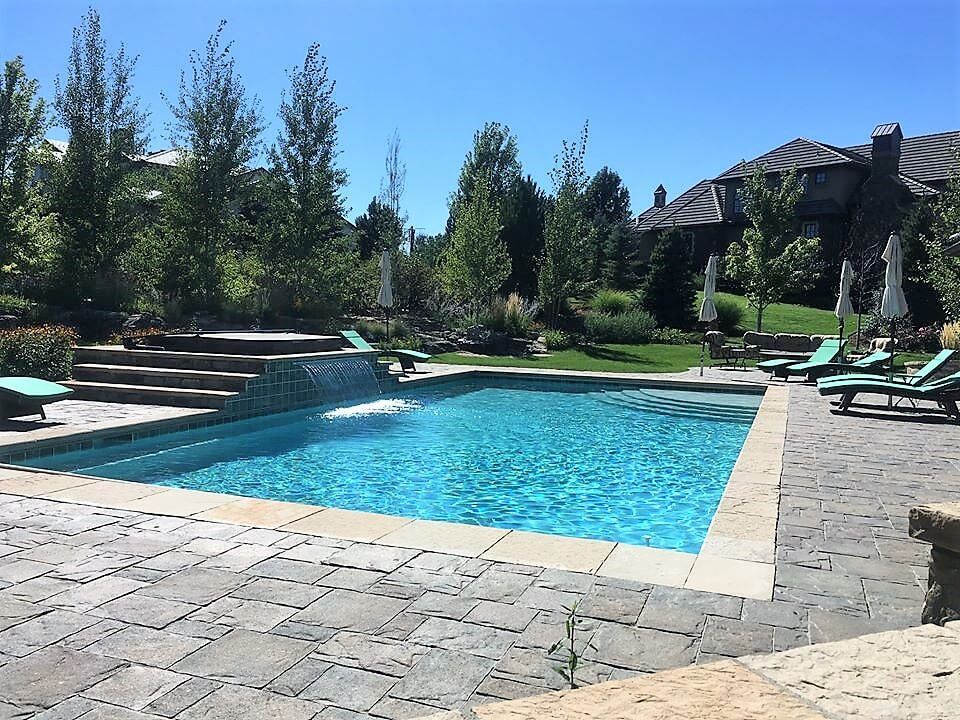 A large swimming pool surrounded by chairs and umbrellas.
