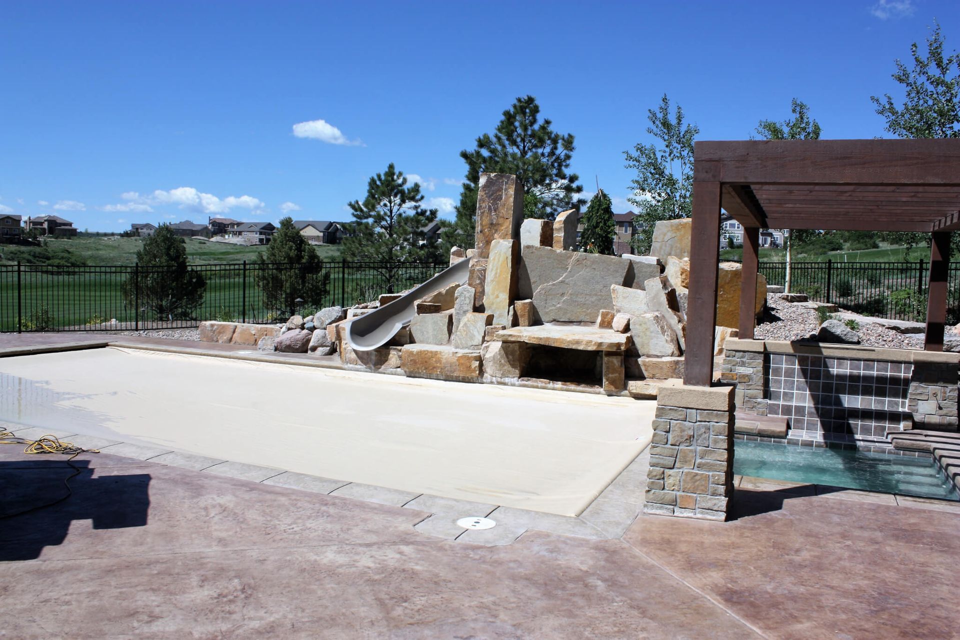 A large swimming pool with a waterfall in the background.
