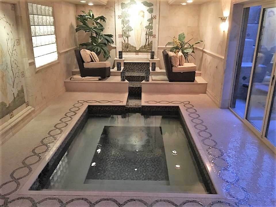 A room with a large pool in the middle of it.