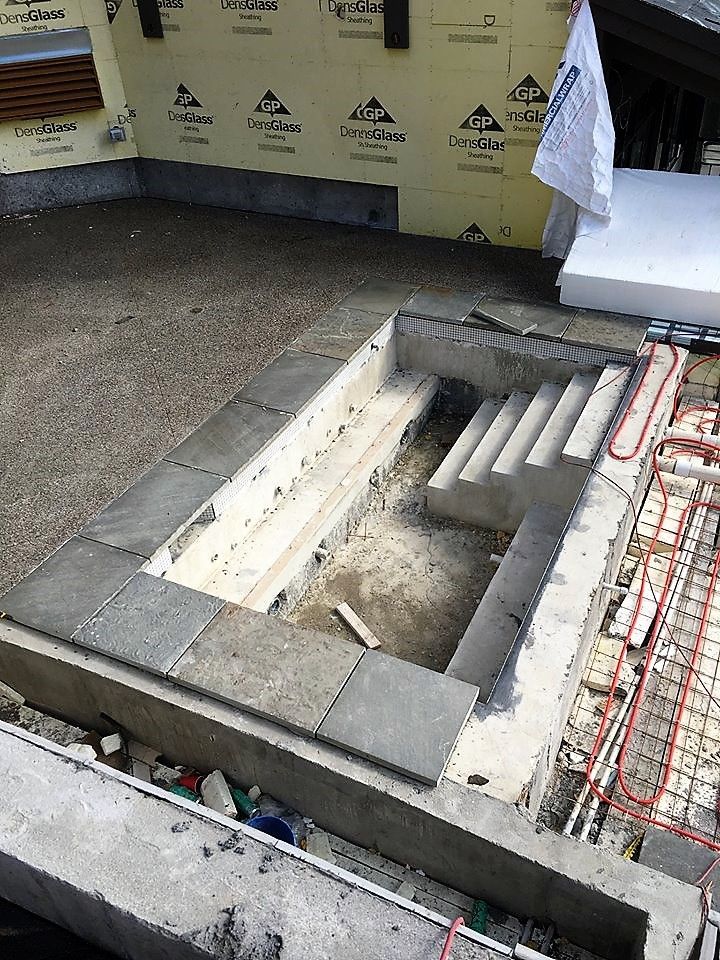 A large hole in the ground is being filled with concrete.