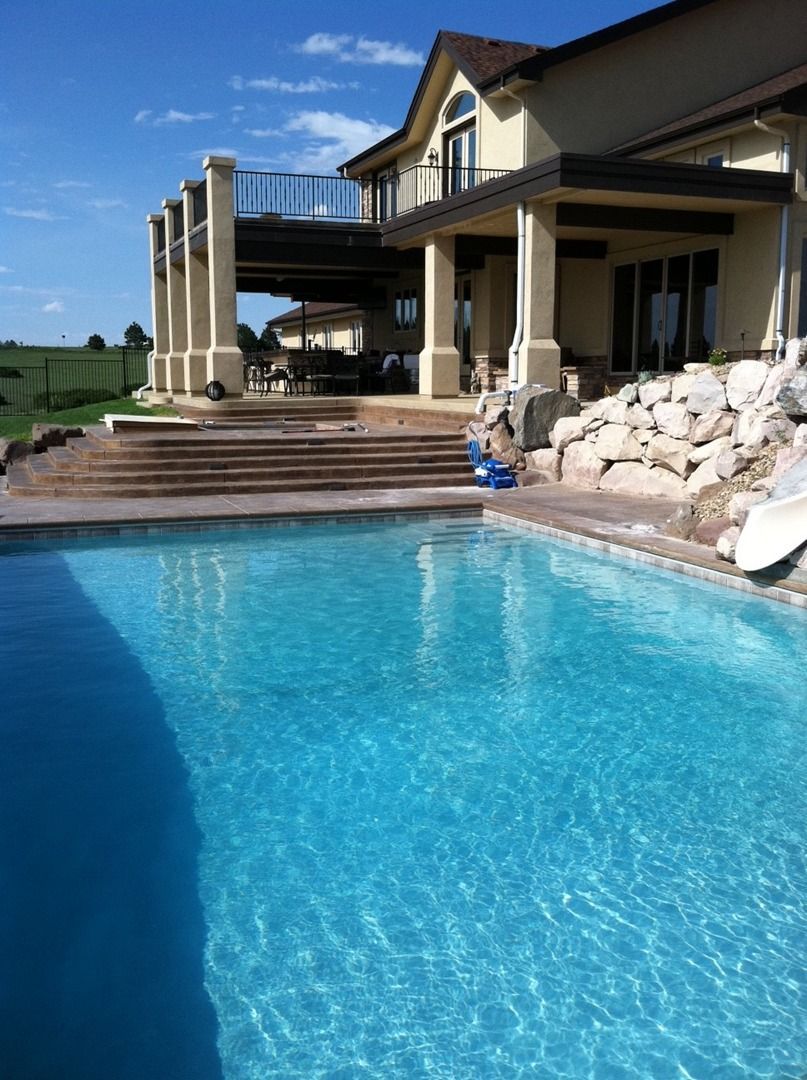 A large house with a swimming pool in front of it.