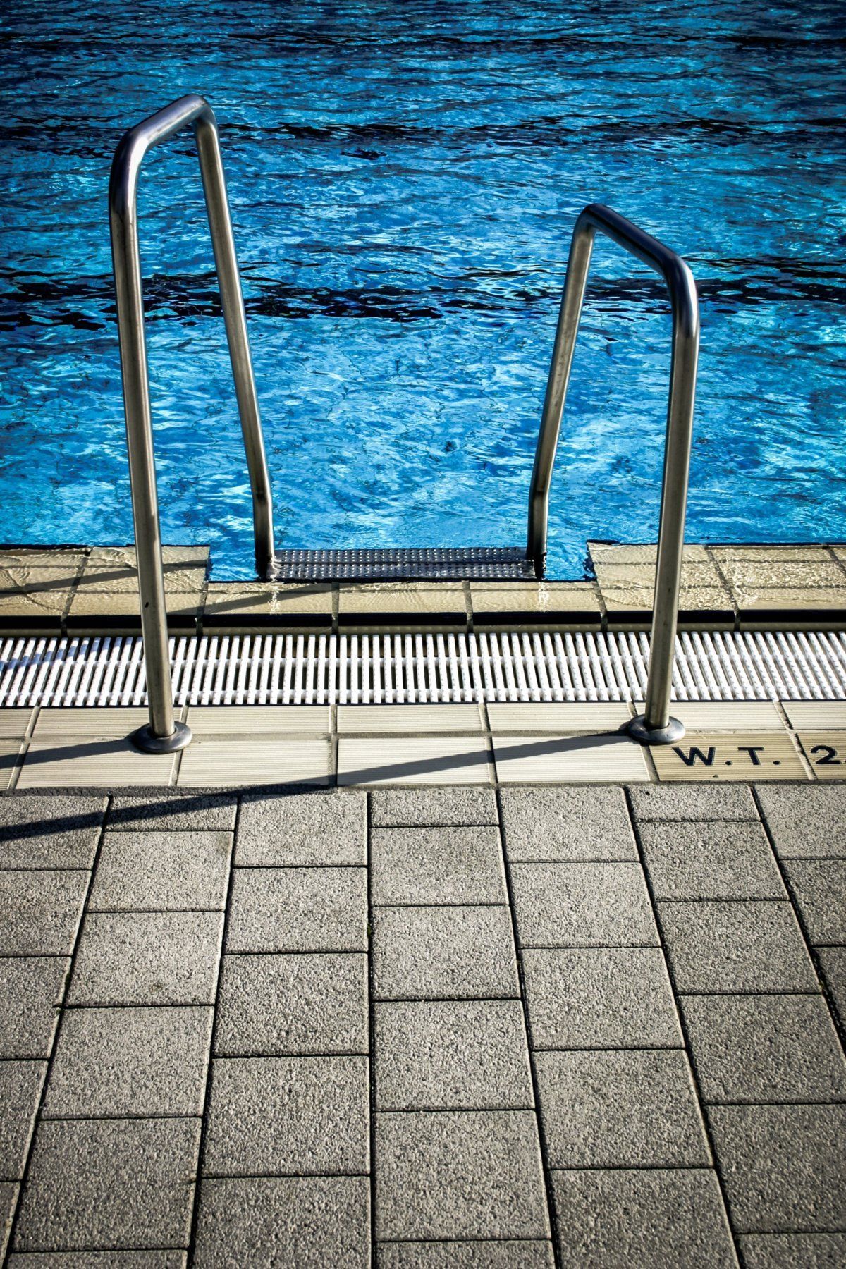 A staircase leading to a swimming pool with blue water.