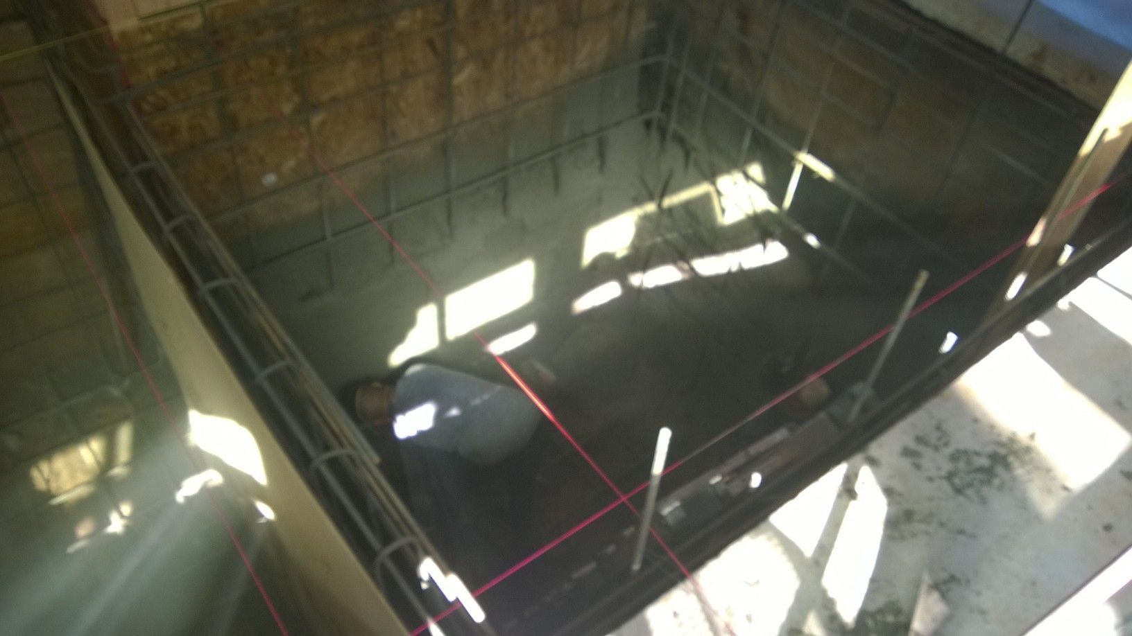 A person is using a red laser to measure the floor.