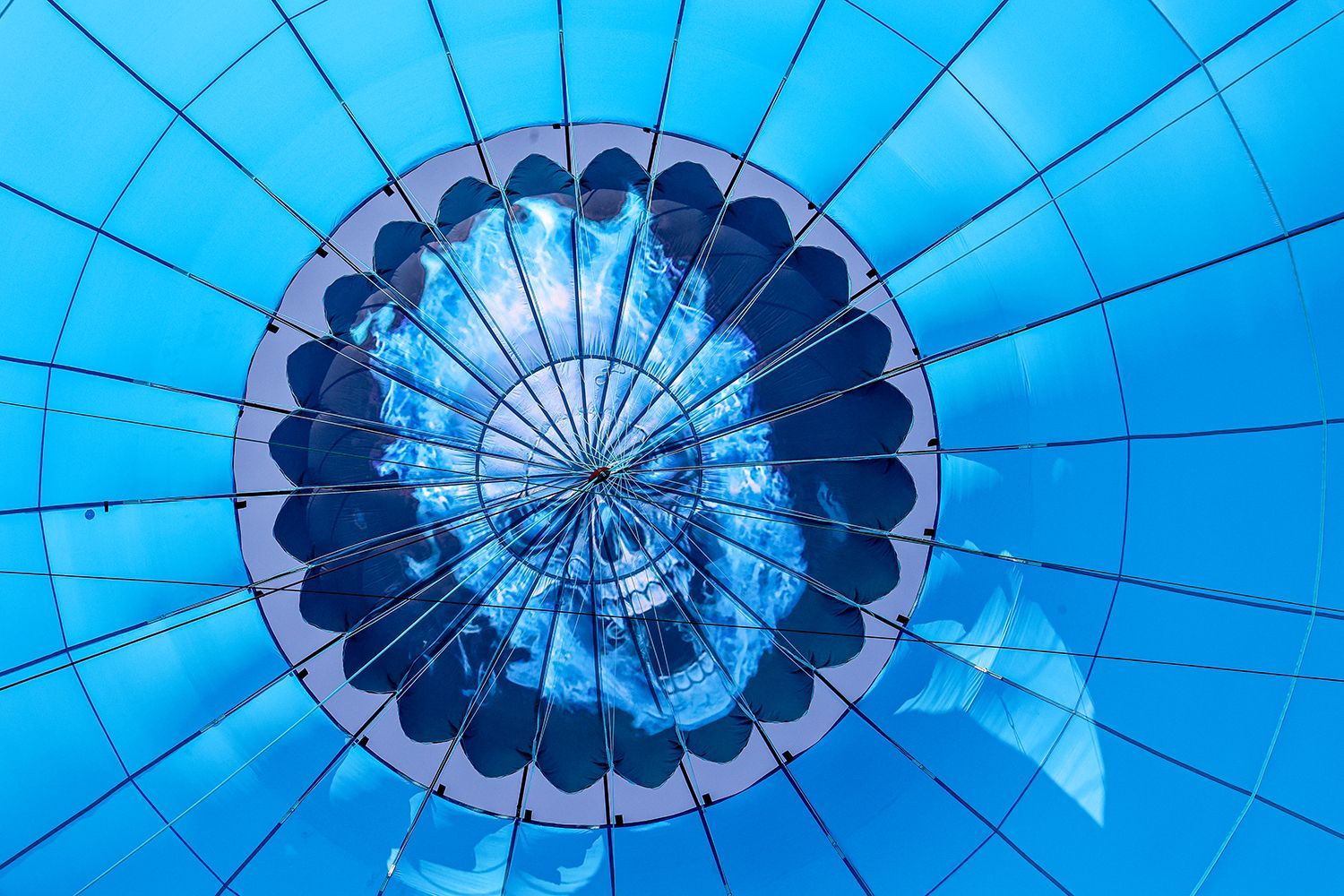 Looking up inside a light blue hot air balloon.
