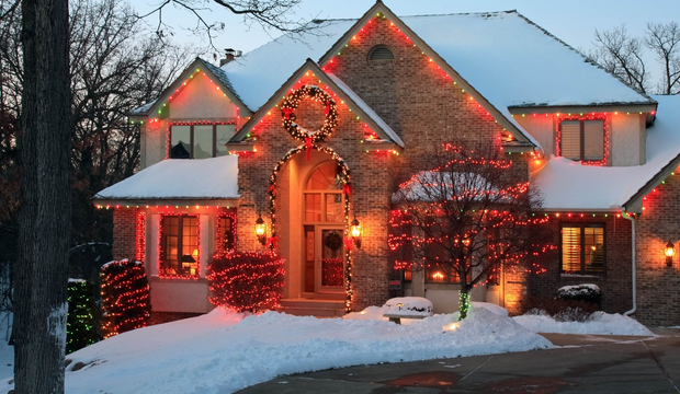 House covered in colorful Christmas lights and decorations at night