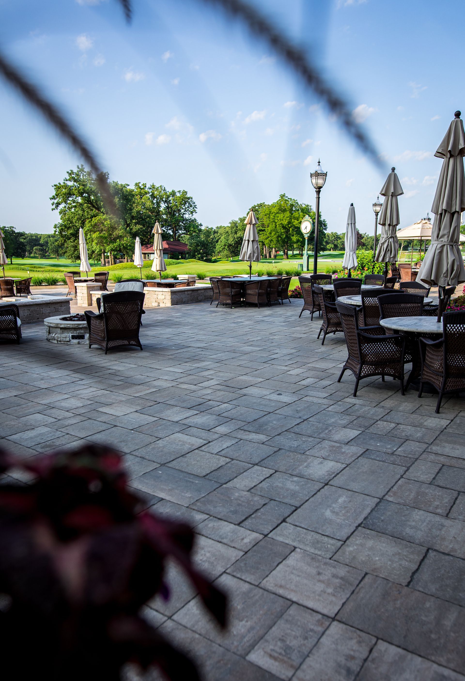 A patio with tables and chairs and umbrellas on a sunny day.
