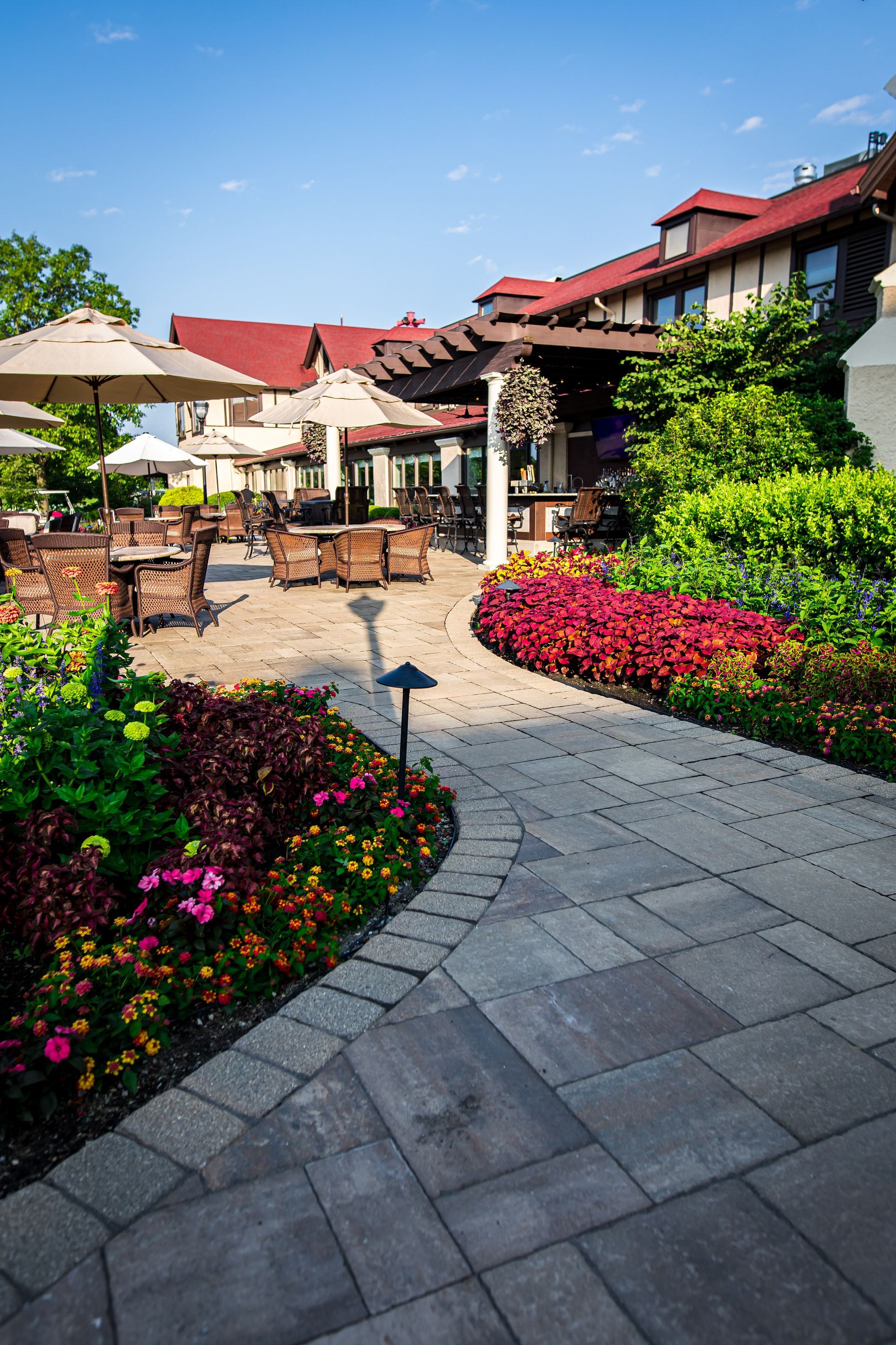 A patio with flowers and chairs in front of a building.