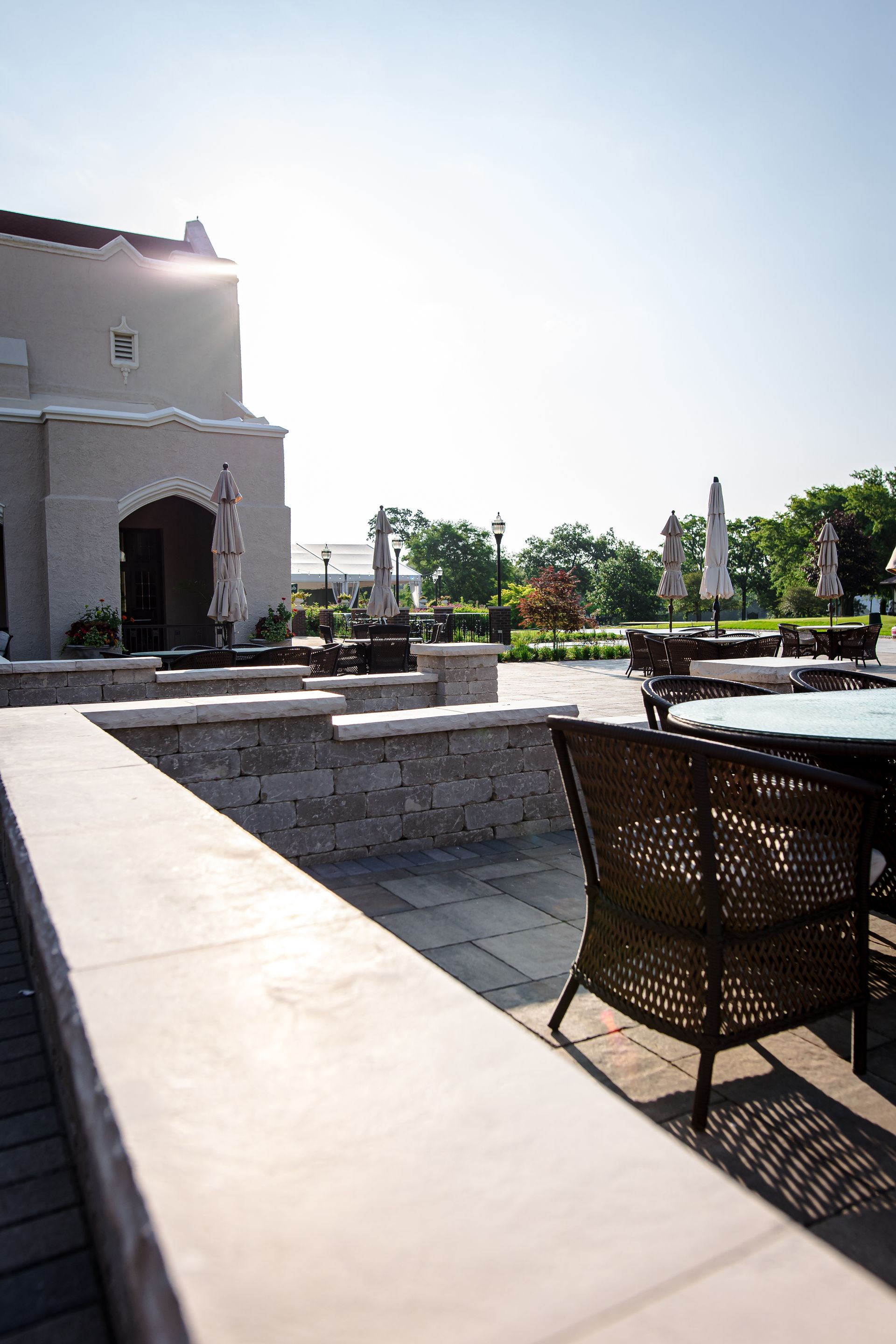 A patio with tables and chairs in front of a building.