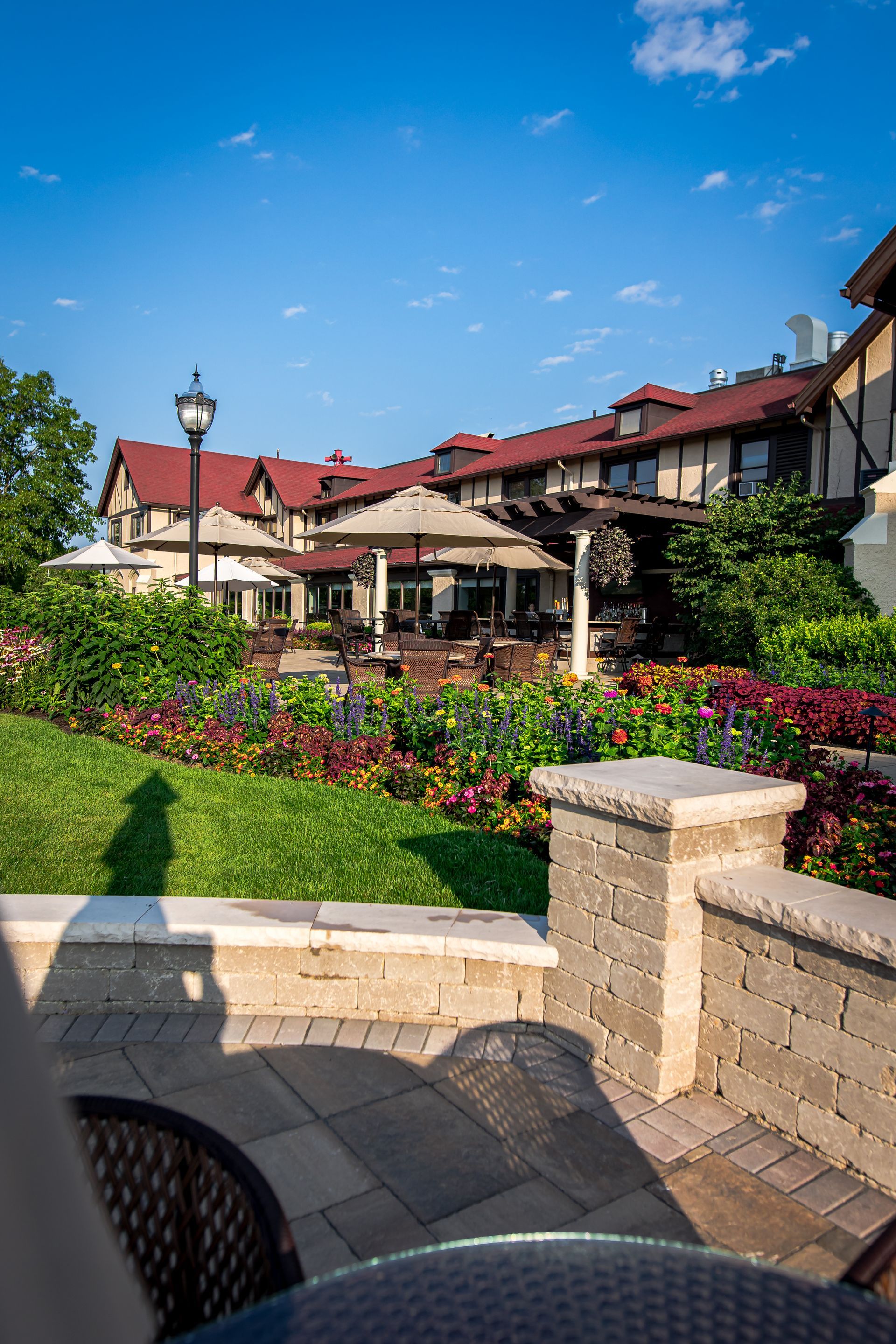 A patio with a table and chairs in front of a large building.
