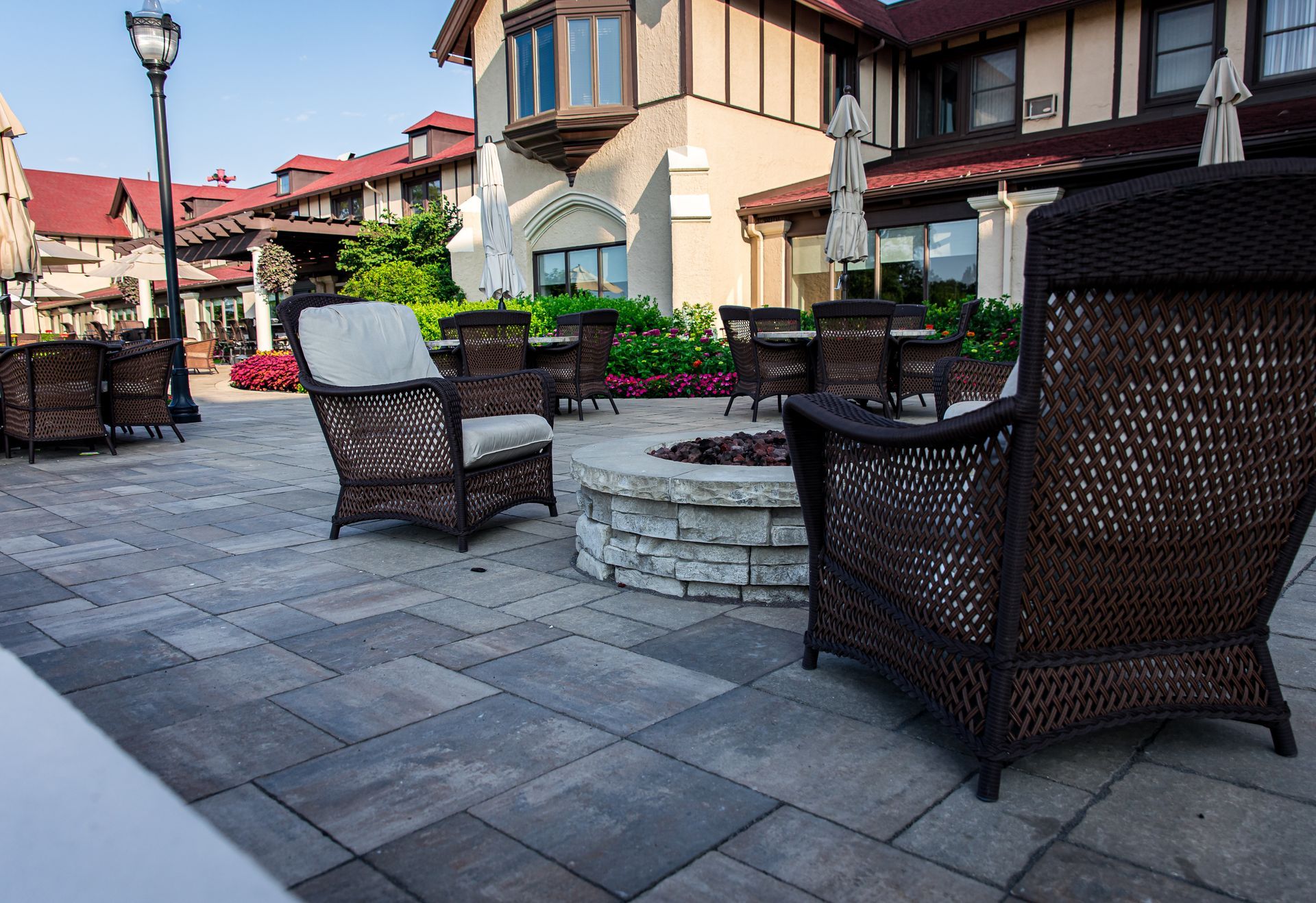 A patio with chairs and a fire pit in front of a building.