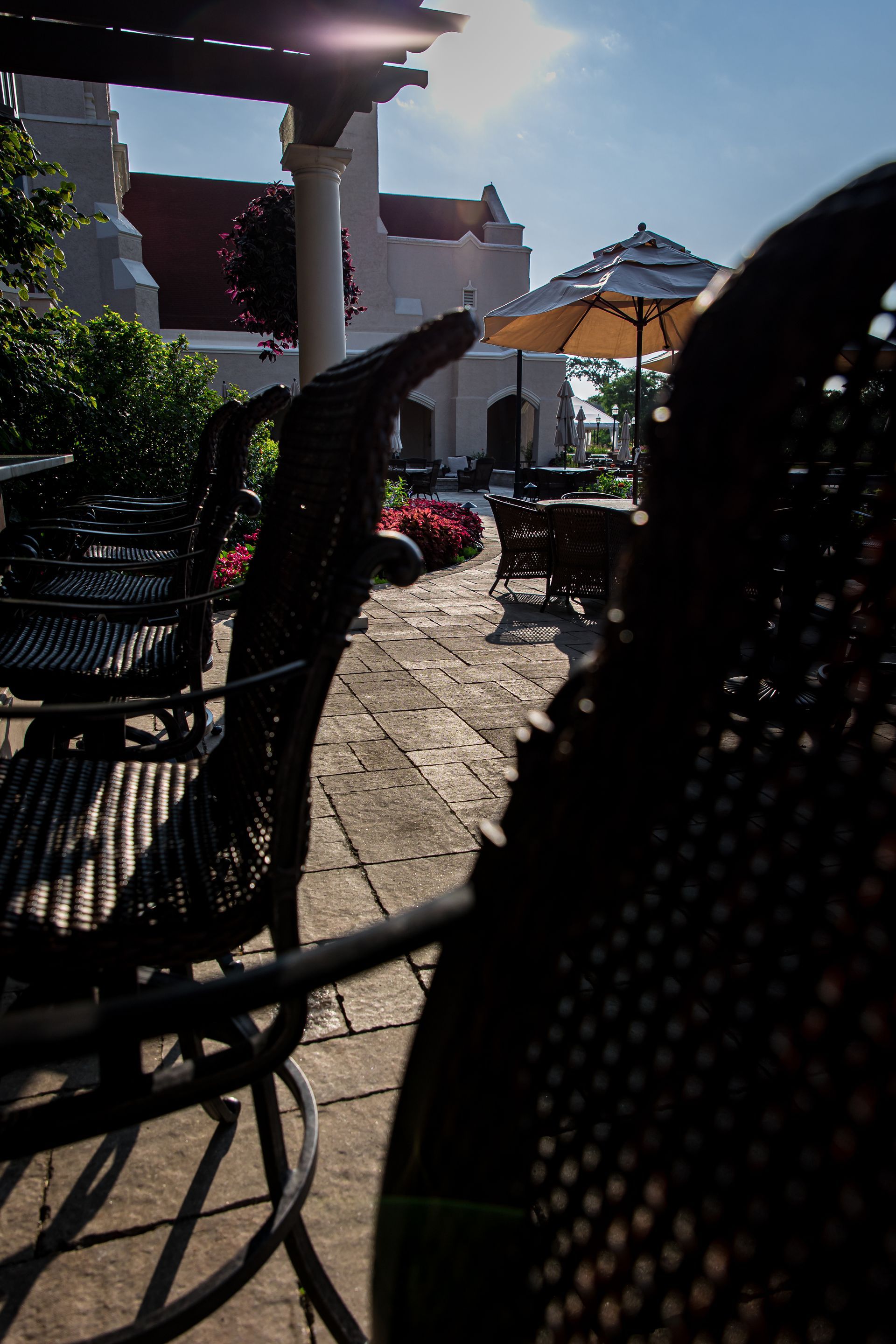A patio with tables and chairs and umbrellas.