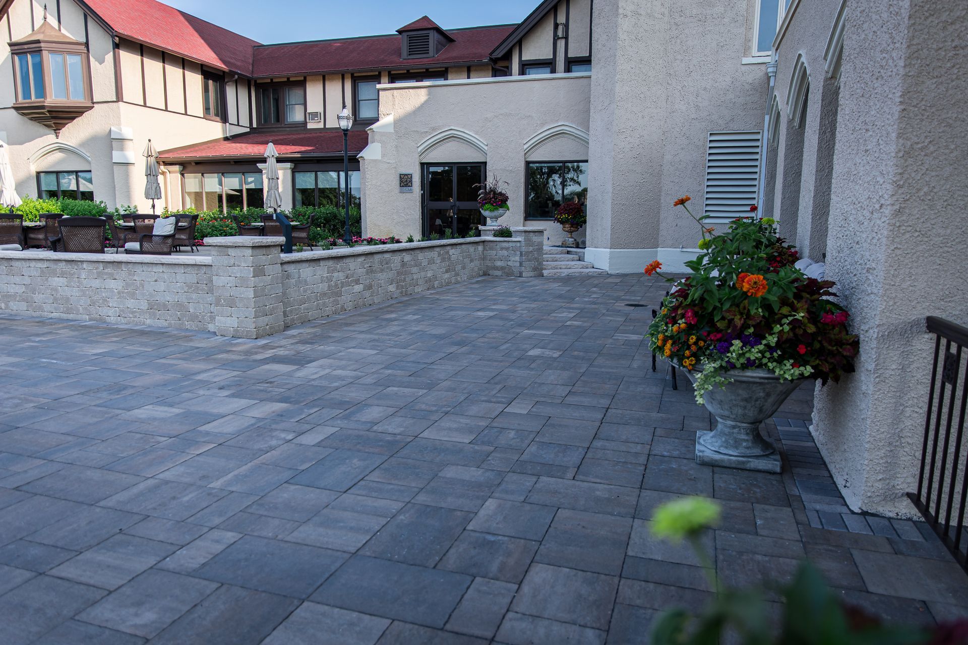 A large building with a patio and flowers in front of it
