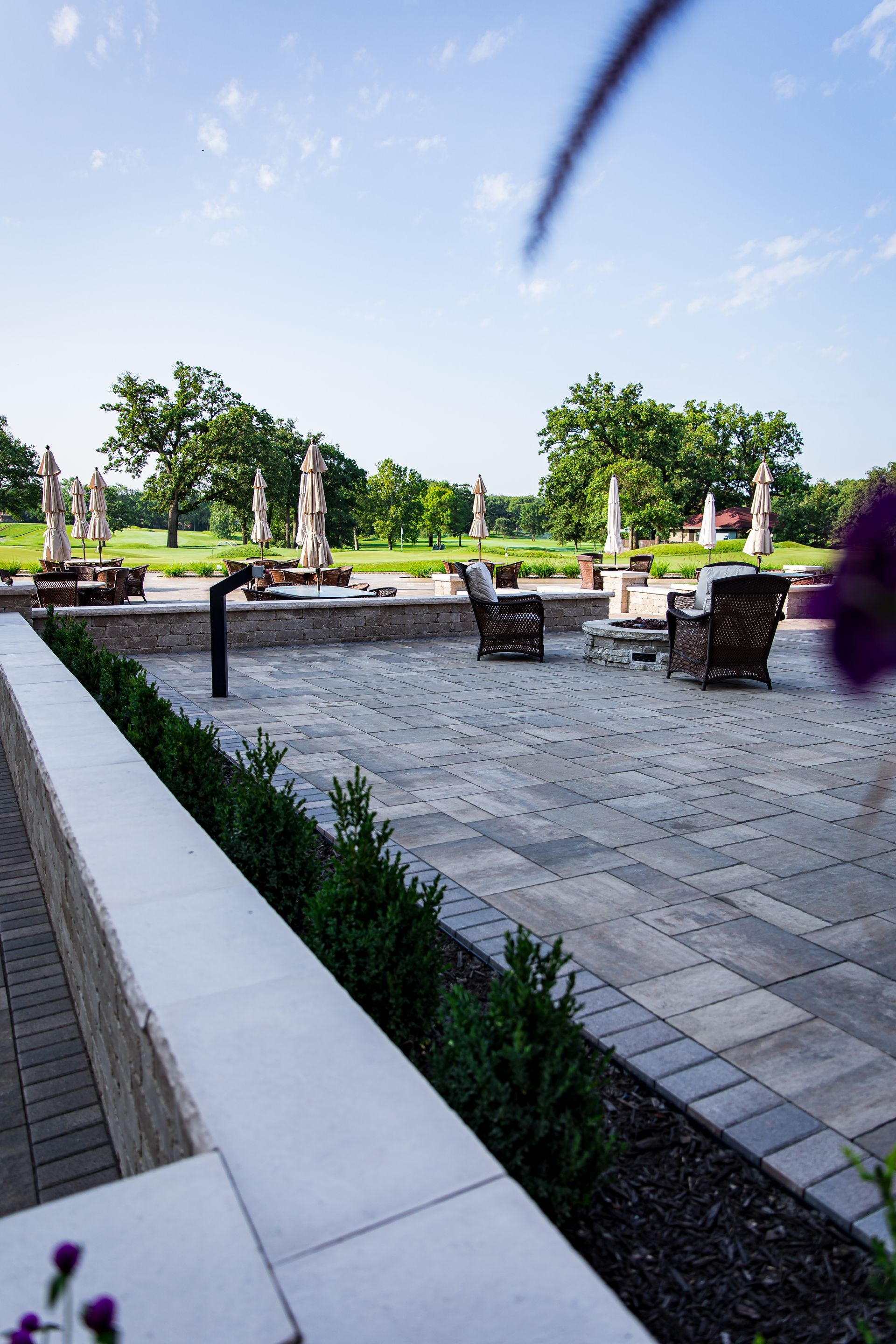 A patio with chairs and umbrellas on a sunny day.