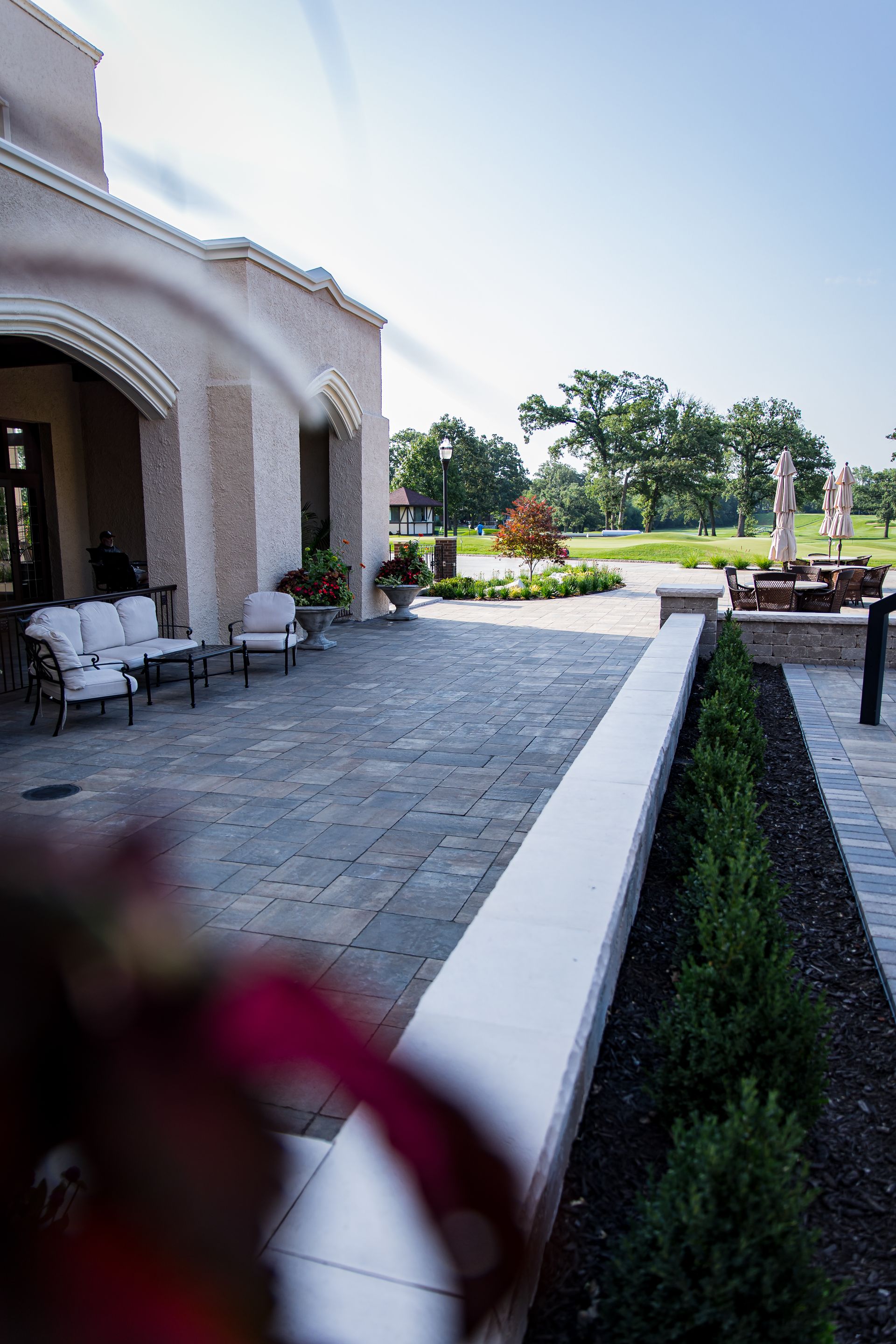 A patio with chairs and umbrellas in front of a building.