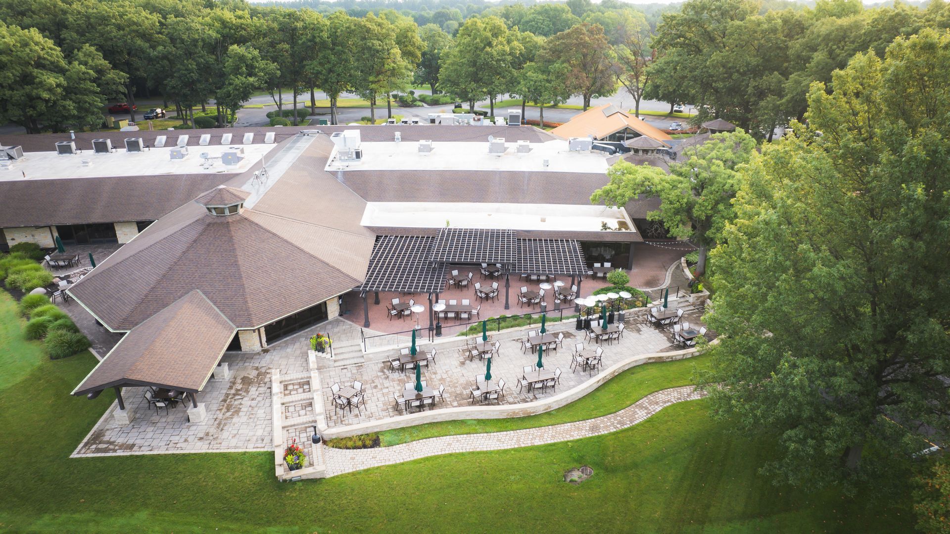 An aerial view of a large building surrounded by trees and grass.